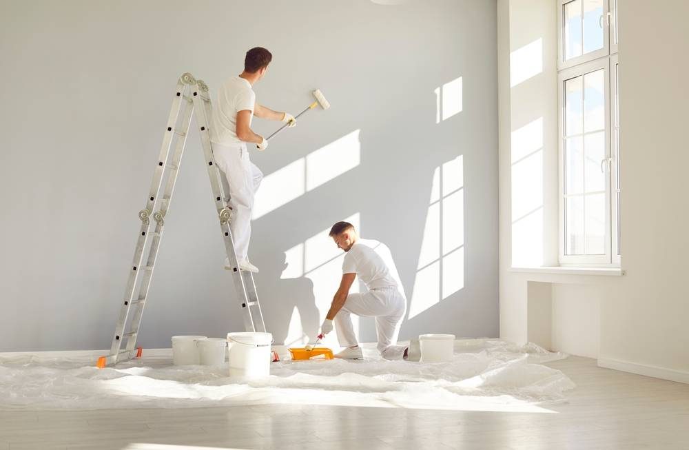 Professional painters working in a bright interior